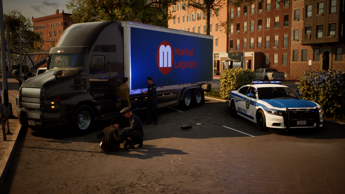 A large semi-truck with a blue side panel reading Madrid Logística is parked in an urban lot alongside a white and blue police car. Several people are gathered around the truck, and brick buildings, trees, and pavement are visible in the background.