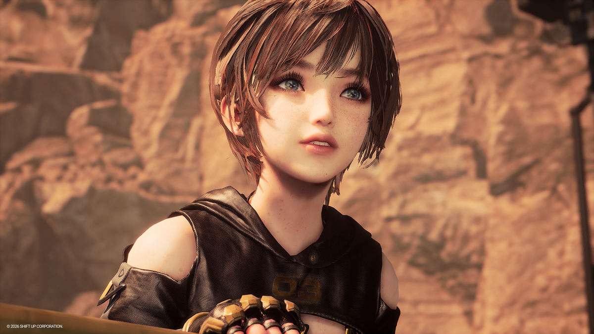 A close-up of a stylized anime character with short brown hair, freckles, and blue eyes, wearing a dark sleeveless top and gold-toned gloves, set against a warm rocky background.