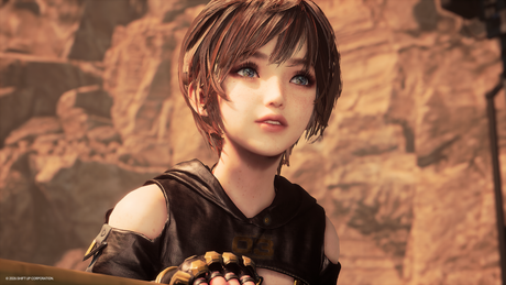 A close-up of a stylized anime character with short brown hair, freckles, and blue eyes, wearing a dark sleeveless top and gold-toned gloves, set against a warm rocky background.